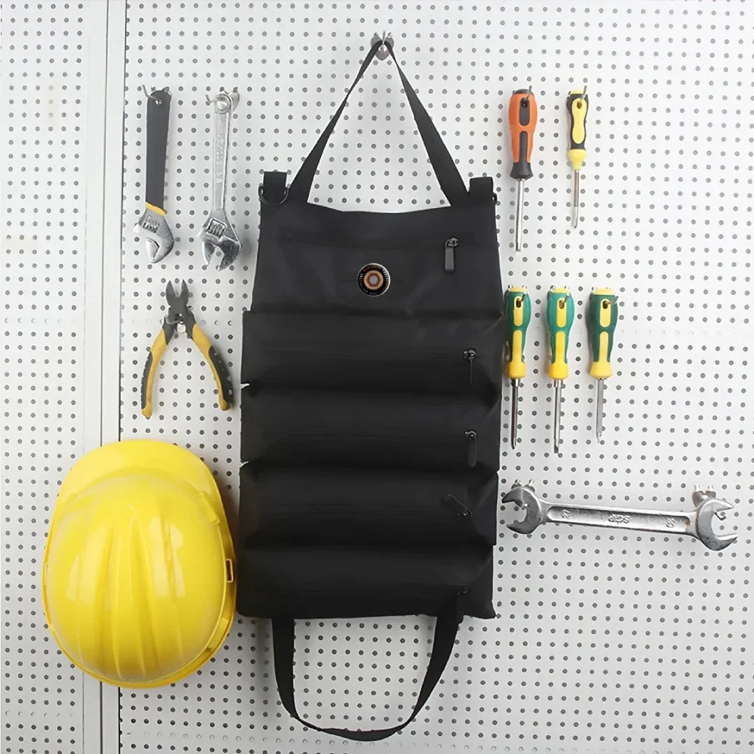 Black roll-up tool storage organizer hanging on pegboard with tools and yellow hard hat