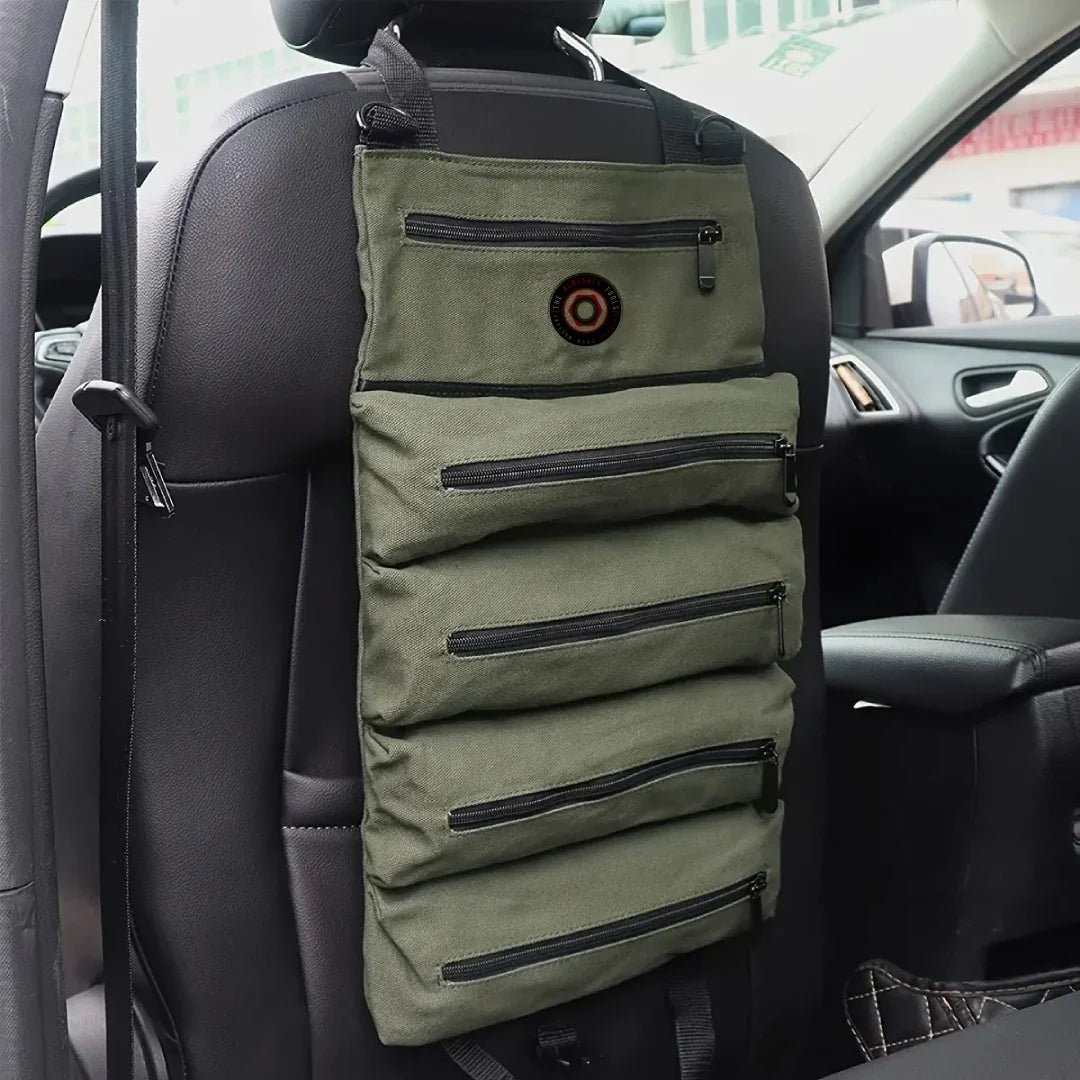 Olive green car seat organizer with multiple zippered pockets hanging on a headrest
