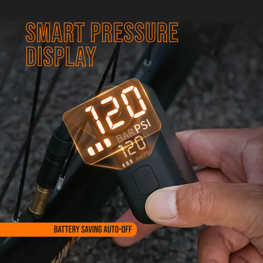 Hand using AirBuddy 5 portable air pump with smart pressure display for bike tire inflation