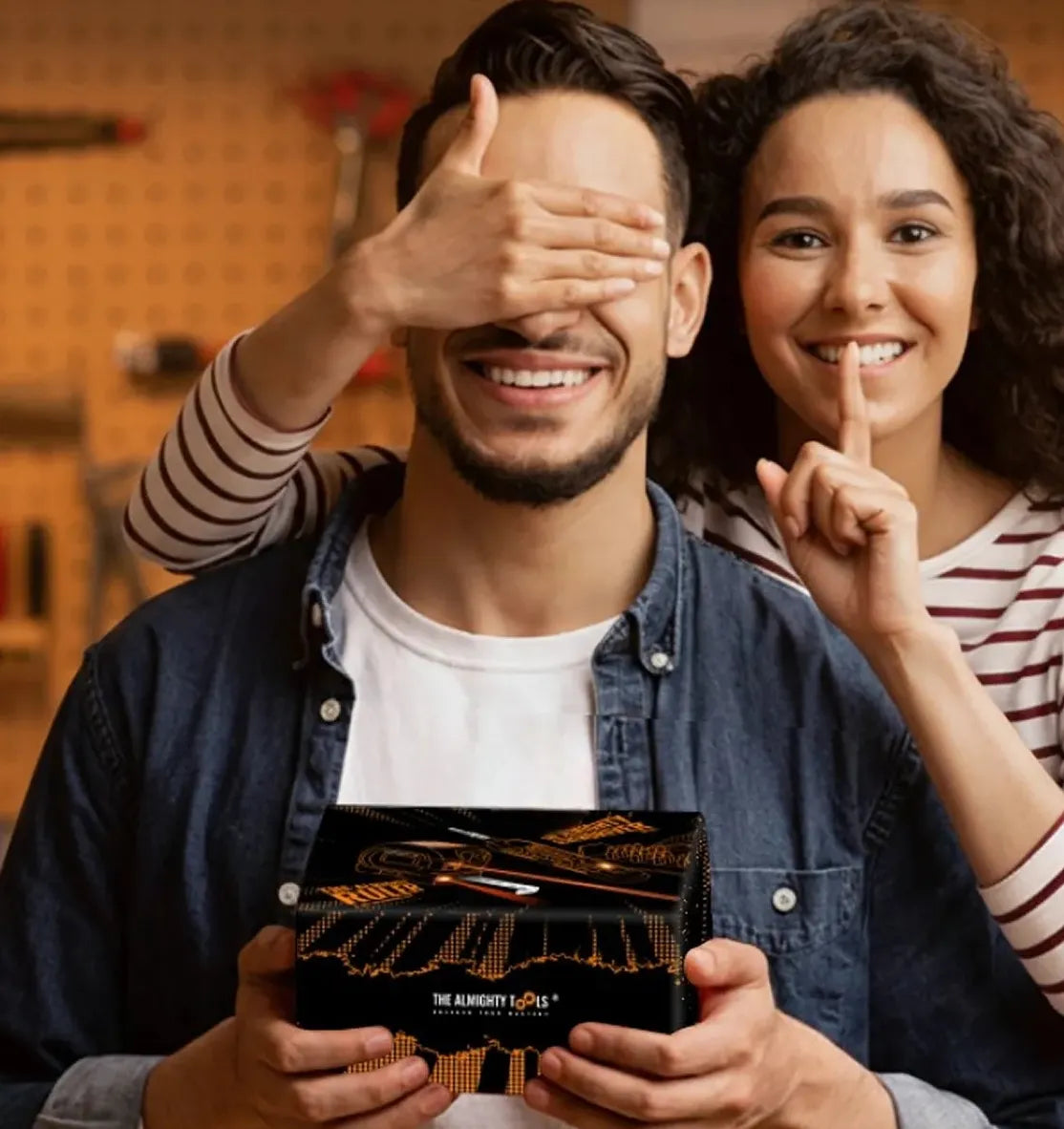 Two people with a box of Riedel wine glasses in a kitchen setting