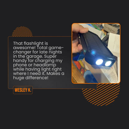 Hand holding a solar power bank flashlight with dual LED lights, garage setting visible.