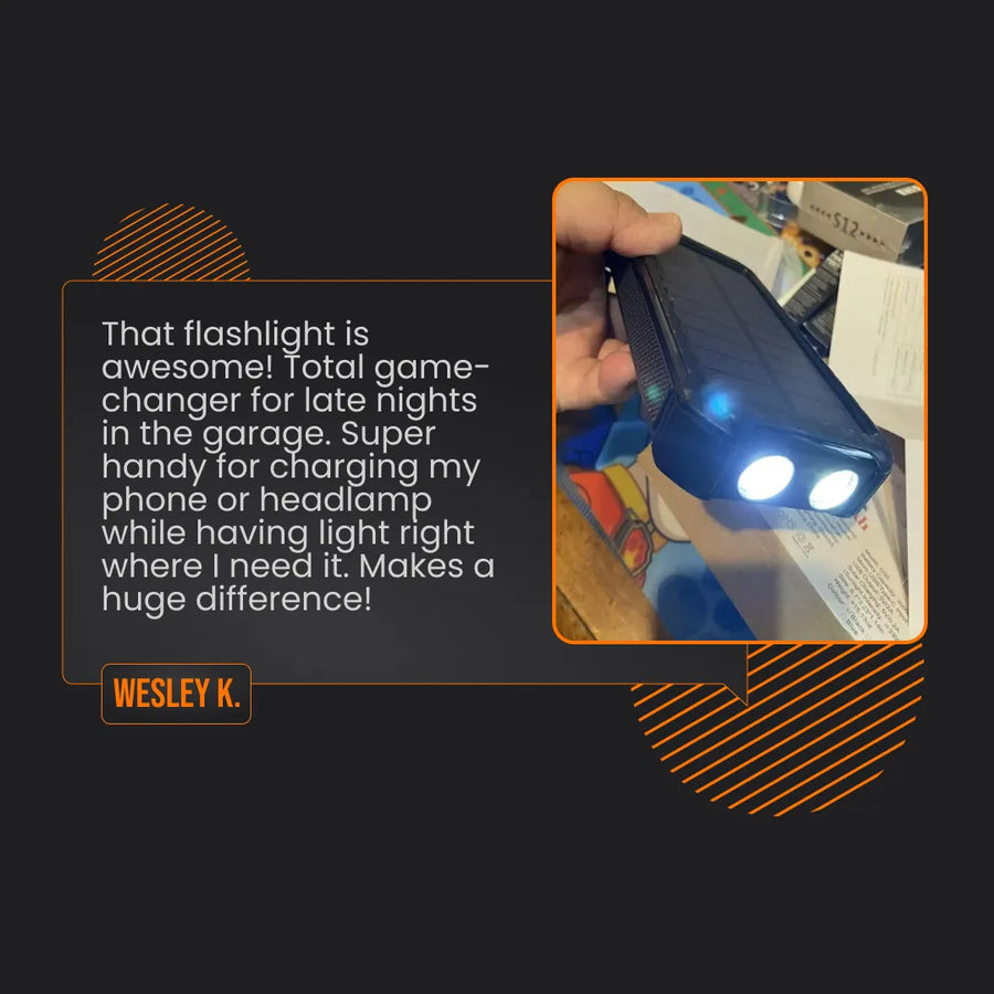 Hand holding a solar power bank flashlight with dual LED lights, garage setting visible.